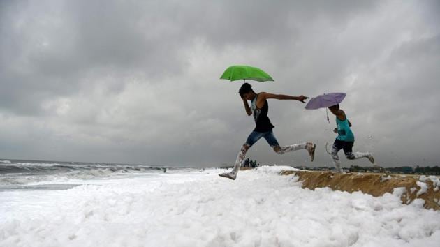 Umbrella-toting youths jump over foamy discharge, caused by pollutants, as it mixes with the surf at a beach in Chennai, Tamil Nadu on November 22, 2018. (Arun Sankar / AFP) Umbrella-toting youths jump over foamy discharge, caused by pollutants, as it mixes with the surf at a beach in Chennai, Tamil Nadu on November 22, 2018. (Arun Sankar / AFP)