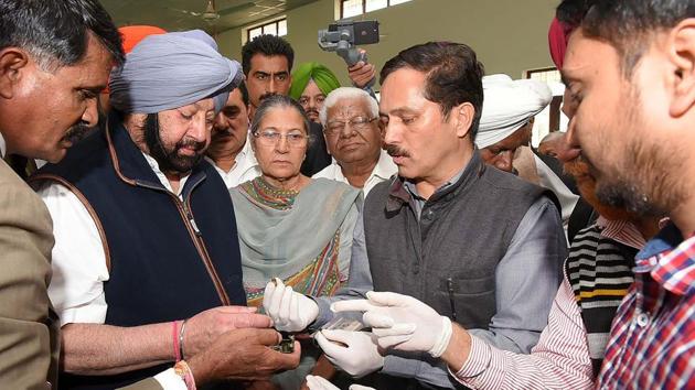 Indian security personnel show fragments of a grenade to Punjab Chief Minister Amarinder Singh (2R), following a grenade attack at the Nirankari Satsang Bhawan in Rajasansi village, on the outskirts of Amritsar(AFP)