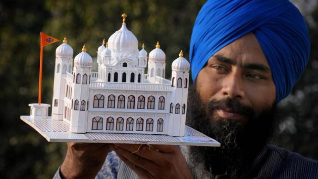 Paper artist Gurpreet Singh shows his creation, a paper model of Guru Nanak Dev Ji's gurudwara (Kartarpur Sahib) in Pakistan, in Amritsar.(PTI)