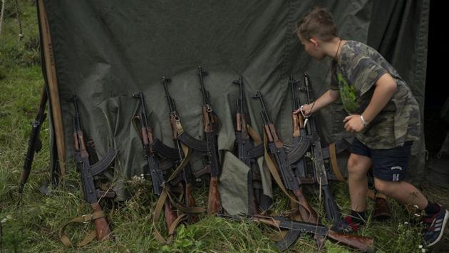 A young participant grabs his AK-47 during a tactical exercise in a village near Ternopil, Ukraine. “We never aim guns at people,” instructor Yuri “Chornota” Cherkashin told campers. “But we don't count separatists, little green men, occupiers from Moscow as people, so we can and should aim at them.” (Felipe Dana / AP) 