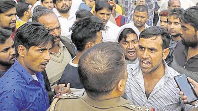 The family of Mohit Yadav, who allegedly hanged himself after shooting his girlfriend, with the police outside the guest house in Noida where the incident occurred. (Salman Ali / HT Photo) The family of Mohit Yadav, who allegedly hanged himself after shooting his girlfriend, with the police outside the guest house in Noida where the incident occurred. (Salman Ali / HT Photo)