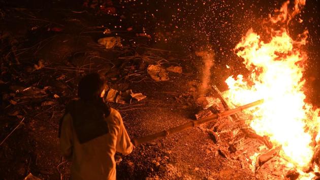 A man stokes a funeral pyre at the traditional crematorium grounds at Harischandra Ghat on the river Ganga in Varanasi, Uttar Pradesh. The ghats of this ancient city witness around 200 cremations per day on the banks of the country’s holiest river. (Dominique Faget / AFP)