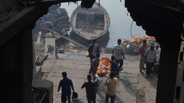 A body is carried to be cremated at Manikarnika Ghat. To reduce the volume used, as well as air and water pollution, authorities have tried to push the use of alternative burning materials such as cow-dung. But without much success. (Dominique Faget / AFP)