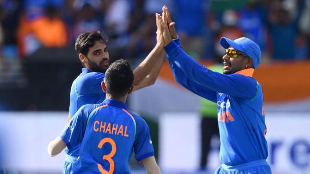 Bhuvneshwar Kumar celebrates with teammates after picking a wicket during a match.(AFP)