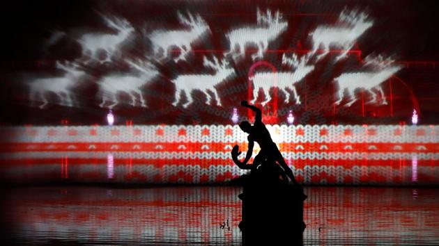 Laser beams create a Christmas-themed image on a sheet of water sprayed into the air. (AFP)