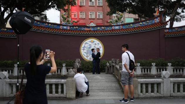 On a sunny day in a park in Taipei, photographer Austin Haung (2nd, L) advises a same-sex couple on how to pose for a pre-wedding photo shoot. For him, Taiwan’s reputation as a beacon of liberalism in the region means a thriving business. (Ann Wang / REUTERS)