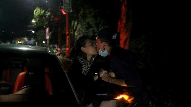 Du Yueting (R), kisses Zhang Tongyu goodbye outside their restaurant. On Saturday, Taiwan held a series of public votes on whether its civil law should now recognise same-sex marriage, after its election authority approved contradicting referendum petitions from both conservative and rights groups. (Ann Wang / REUTERS)