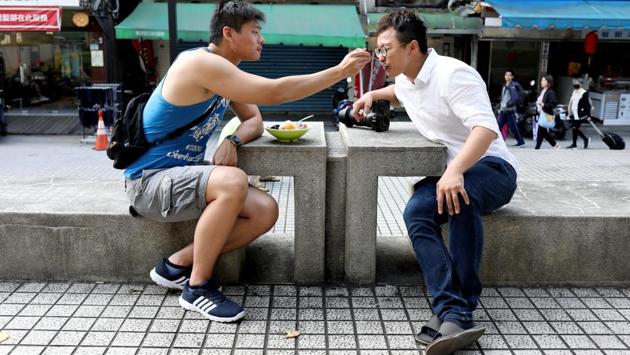 Lin Chinxuan feeds Haung a dessert. The issue has divided Taiwan, at family dining room tables, online and on the streets. Haung, who is gay, plans to vote for same-sex marriage, but his mother Zeng, in her early 60s, staunchly objects. In fact, she has rallied relatives and friends to support the opposing referendum that defines marriage as between a man and a woman. (Ann Wang / REUTERS)