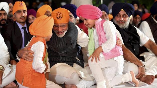 PM Narendra Modi interacts with children at a programme to celebrate Guru Nanak Dev Ji's birth anniversary, at the residence of Union minister Harsimrat Kaur in New Delhi on Friday, November 23, 2018.(PTI)