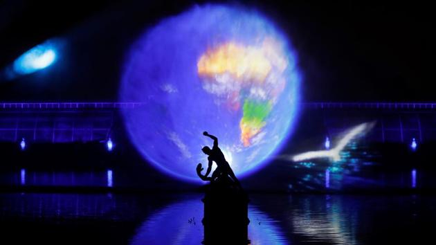 Laser beams create images projected onto a sheet of water sprayed into the air. (AFP)