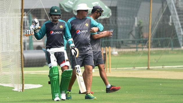 Pakistani cricket team coach Mickey Arthur (C) walks with a team cricketer during the team practise at the Gaddafi stadium in Lahore(AFP)
