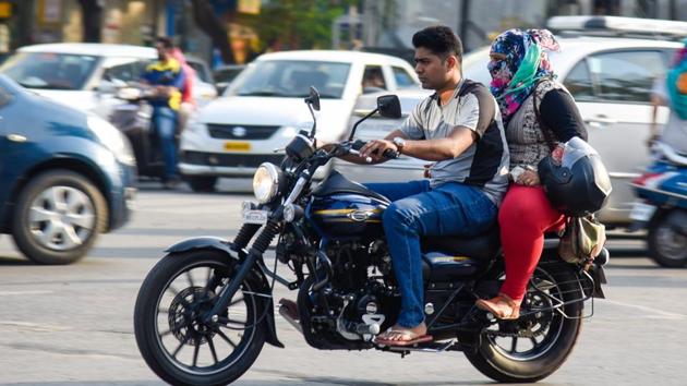 While the man is driving a motorbike without a helmet the women is carrying it like a bag. With increasing population and increase in number of vehicles that run on the roads on a day-to-day basis, Pune traffic incharge bodies have made wearing helmet compulsory from January 1. (HT FILE PHOTO) While the man is driving a motorbike without a helmet the women is carrying it like a bag. With increasing population and increase in number of vehicles that run on the roads on a day-to-day basis, Pune traffic incharge bodies have made wearing helmet compulsory from January 1. (HT FILE PHOTO)