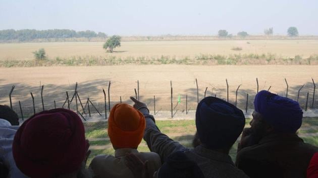 Sikh devotees look out towards the Gurdwara Kartarpur Sahib, which is situated in Pakistan, from Dera Baba Nanak on the outskirts of Amritsar on November 25. (AFP Photo) Sikh devotees look out towards the Gurdwara Kartarpur Sahib, which is situated in Pakistan, from Dera Baba Nanak on the outskirts of Amritsar on November 25. (AFP Photo)