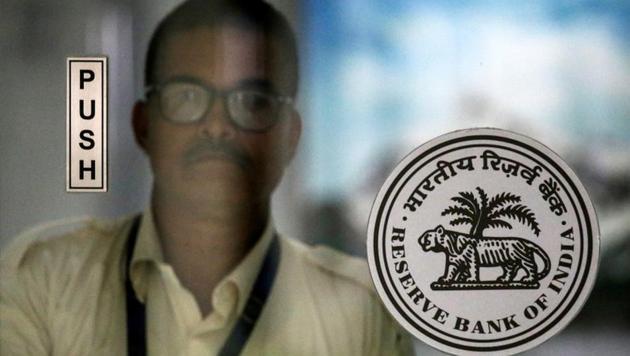 An employee walks behind the Reserve Bank of India logo inside its headquarters in Mumbai.(REUTERS) An employee walks behind the Reserve Bank of India logo inside its headquarters in Mumbai.(REUTERS)