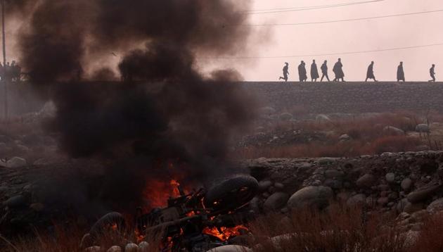 Protesters walk past a burning motorbike during clashes with police following the killing of six suspected militants in south Kashmir's Shopian district November 25, 2018.(Reuters)