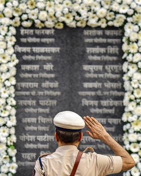 A police officer pays his respects at Martyrs’ Memorial to those who laid down their lives defending the city against the terror attacks. (HT Photo)