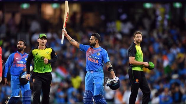 Virat Kohli raises his bat after taking India home in the third T20I in Sydney.(AFP)