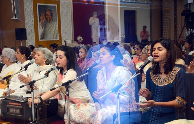 A double exposure picture of Sadhu Vaswani's photo and his devotees during the prayer song session at Sadhu Vaswani mission on the occasion of international meatless day in Pune on November 25. (Shankar Narayan/HT PHOTO)