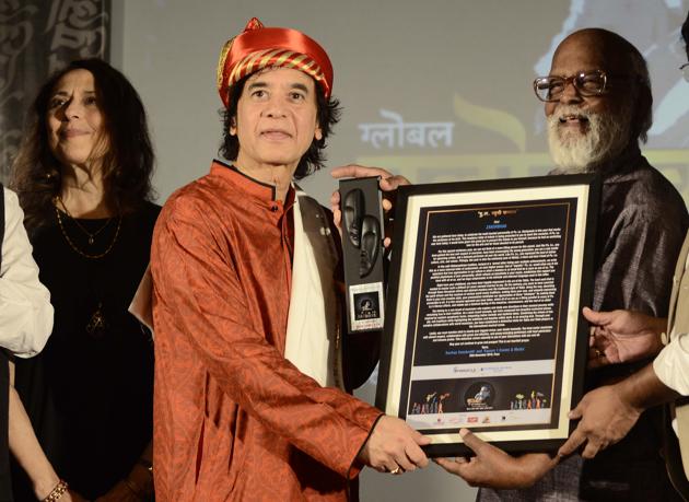 Tabla maestro Zakir Hussain (M)being awarded the Pu La sanman by Raj Dutt (R),film director at Pulotsav 2018,while Zakir’s wife, Antonia Minnecola (L)watches in Pune, on November 25. (Ravindra Joshi/HT PHOTO)
