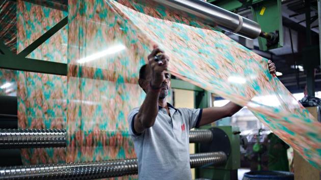 A worker inspects a piece of printed fabric as it runs through a machine during the manufacturing of Lakshmipati Sarees brand garments at the Siddhi Vinayak Knots & Prints Ltd. factory in Surat, Gujarat. The manufacturing sector contributes about 15 percent of the India's gross domestic product. (Bloomberg) A worker inspects a piece of printed fabric as it runs through a machine during the manufacturing of Lakshmipati Sarees brand garments at the Siddhi Vinayak Knots & Prints Ltd. factory in Surat, Gujarat. The manufacturing sector contributes about 15 percent of the India's gross domestic product. (Bloomberg)