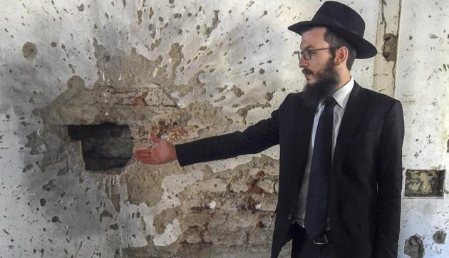 Chabad House Mumbai director Rabbi Israel Kozlovsky gestures at bullet marks from the 26/11 attacks.(PTI)