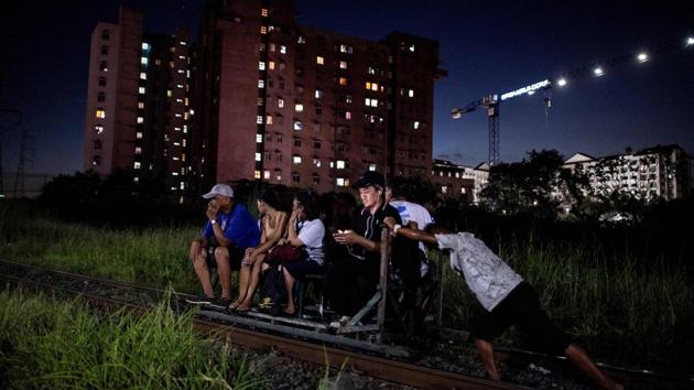 As soon as the train rumbles past, the men heave their home-made pushcarts back onto the tracks and passengers hop aboard -- cheating death and beating Manila’s notorious traffic. Scores of commuters in the city of about 12 million are propelled to their destinations daily by so-called “trolley boys” pushing metal carts that ply a few segments of the sprawling capital’s railroads. (Noel Celis / AFP) As soon as the train rumbles past, the men heave their home-made pushcarts back onto the tracks and passengers hop aboard -- cheating death and beating Manila’s notorious traffic. Scores of commuters in the city of about 12 million are propelled to their destinations daily by so-called “trolley boys” pushing metal carts that ply a few segments of the sprawling capital’s railroads. (Noel Celis / AFP)