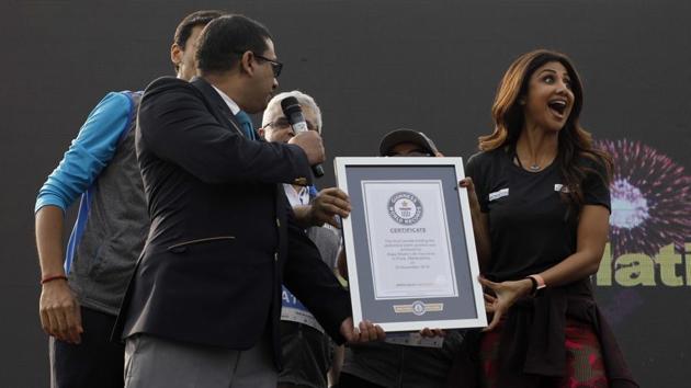 Shilpa Shetty Kundra receiving the Guinness world record from the officials for the most number of people holding the abdominal plank position simultaneously for one minute on behalf of Bajaj alliance life insurance for the Bajaj life Plankton at AFMC ground Wanowrie in Pune, on November 25. (Rahul Raut/HT PHOTO)