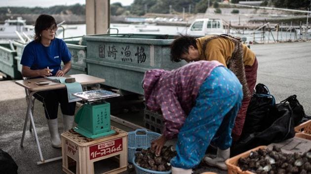 Freediving ama fisherwomen sell their catch after a dive. During the diving season, which lasts for 10 months a year, the local fishing association scrutinises weather forecasts and information on marine stocks each day, before issuing a call for the women from loudspeakers. (Martin Bureau / AFP)