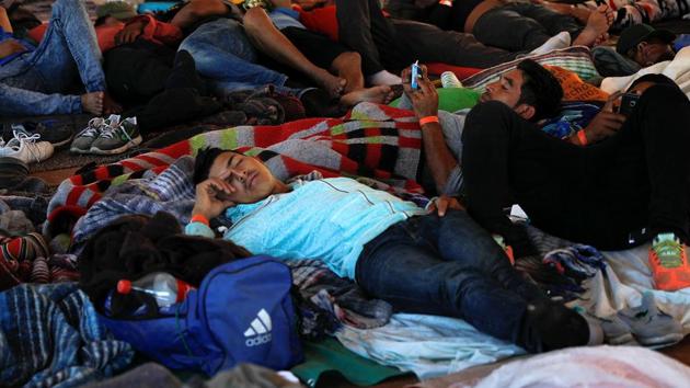 Migrants, part of a caravan of thousands from Central America trying to reach the United States, resting under a tent at a temporary shelter in Tijuana, Mexico. (REUTERS) Migrants, part of a caravan of thousands from Central America trying to reach the United States, resting under a tent at a temporary shelter in Tijuana, Mexico. (REUTERS)