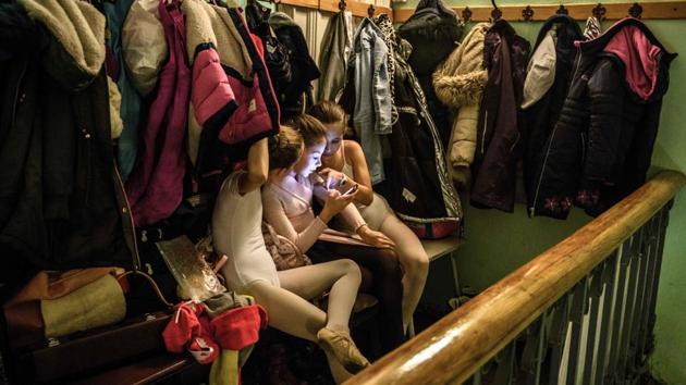 Girls use a smartphone at the dressing area of a ballet studio. Mironova stressed that while “you have to shout a bit” during a class, the teachers are “warm” to the children. (Mladen Antonov / AFP) Girls use a smartphone at the dressing area of a ballet studio. Mironova stressed that while “you have to shout a bit” during a class, the teachers are “warm” to the children. (Mladen Antonov / AFP)