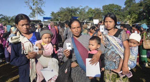 Bru tribal women show their identity card as they wait to cast their vote at a polling station for the state elections, at Kanhmun, Mizoram on November 28.(PTI Photo)