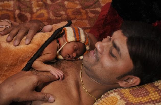 Neeraj Kumar of Ram Sagar Nagar giving skin to skin care to his daughter.(HT Photo)
