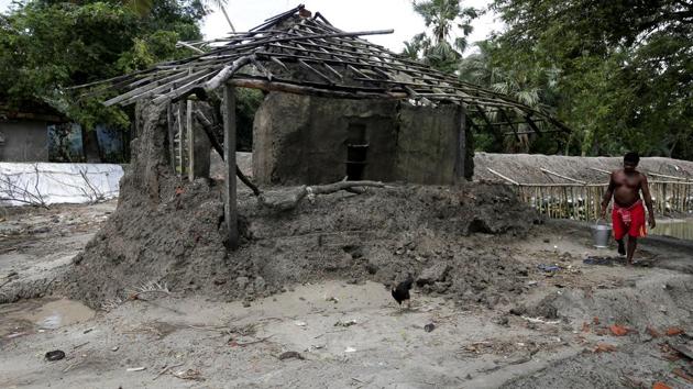 A man walks past a house which was damaged by a high tide. Ghoramara is among many islands in the delta affected by rising sea levels and soil erosion which experts say is caused by climate change. (Rupak De Chowdhuri / REUTERS) A man walks past a house which was damaged by a high tide. Ghoramara is among many islands in the delta affected by rising sea levels and soil erosion which experts say is caused by climate change. (Rupak De Chowdhuri / REUTERS)