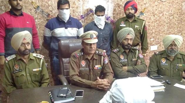 Police officials address media regarding the arrest of drug peddlers (face covered) and recovery of intoxicants from them in Ludhiana on Wednesday, November 28, 2018.(HT Photo) Police officials address media regarding the arrest of drug peddlers (face covered) and recovery of intoxicants from them in Ludhiana on Wednesday, November 28, 2018.(HT Photo)