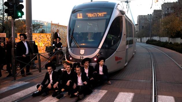 Israeli ultra-Orthodox Jewish men block the road during a protest against the detention of a member of their community who refuses to serve in the Israeli army, in Jerusalem. (Ronen Zvulun / REUTERS) Israeli ultra-Orthodox Jewish men block the road during a protest against the detention of a member of their community who refuses to serve in the Israeli army, in Jerusalem. (Ronen Zvulun / REUTERS)