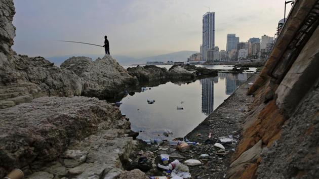 A man casts his fishing pole in the Mediterranean Sea on a rocky coastal area along the Beirut coastline. Once a source of pride, the country’s Mediterranean coastline has become a source of shame for many Lebanese because of the swirling trash that pollutes its shores. (Hassan Ammar / AP) A man casts his fishing pole in the Mediterranean Sea on a rocky coastal area along the Beirut coastline. Once a source of pride, the country’s Mediterranean coastline has become a source of shame for many Lebanese because of the swirling trash that pollutes its shores. (Hassan Ammar / AP)