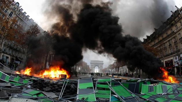 Material burns during a protest against rising oil prices and living costs by Yellow vests (Gilets jaunes) near the Arc of Triomphe on the Champs Elysees in Paris. The ‘yellow vest’ protesters have been demanding French President Emmanuel Macron roll back tax hikes on motor fuel. (AFP) Material burns during a protest against rising oil prices and living costs by Yellow vests (Gilets jaunes) near the Arc of Triomphe on the Champs Elysees in Paris. The ‘yellow vest’ protesters have been demanding French President Emmanuel Macron roll back tax hikes on motor fuel. (AFP)
