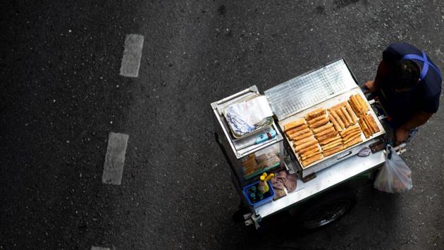A vendor pushes his food cart looking for customers along a street in Bangkok, Thailand. (Jewel Samad / AFP) A vendor pushes his food cart looking for customers along a street in Bangkok, Thailand. (Jewel Samad / AFP)