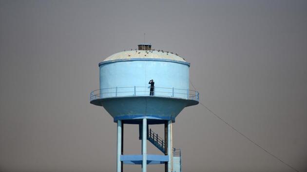 A security personnel watches from atop a water tank near the ‘Dharam Sabha’ Hindu congregation held to call for the construction of a grand temple of Lord Rama, in Ayodhya, Uttar Pradesh on November 25, 2018. (Sanjay Kanojia / AFP)