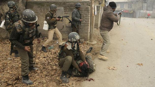 A paramilitary soldier holds his colleague wounded during clash with protestors near the site of a gunfight, in Chattergam, Budgam district, central Kashmir on November 28, 2018. (Waseem Andrabi / HT Photo)