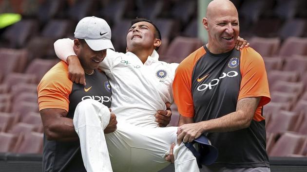 Prithvi Shaw, center, is carried by support staff after rolling his ankle while attempting a catch during their tour cricket match.(AP) Prithvi Shaw, center, is carried by support staff after rolling his ankle while attempting a catch during their tour cricket match.(AP)