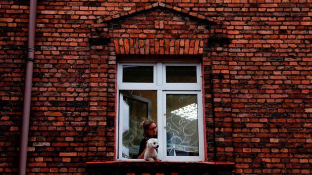 A woman with a dog looks out from a window in Nikiszowiec district. The people miss the community spirit even if it meant shared danger and hardship. “On Friday or Saturday evening people were coming out to sit on the banks, drink some beer, have a barbecue. Now I do not know most of those who have come here,” Zawisza said. (Kacper Pempel / REUTERS) A woman with a dog looks out from a window in Nikiszowiec district. The people miss the community spirit even if it meant shared danger and hardship. “On Friday or Saturday evening people were coming out to sit on the banks, drink some beer, have a barbecue. Now I do not know most of those who have come here,” Zawisza said. (Kacper Pempel / REUTERS)