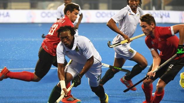 South Africa's Jethro Eustice controls the ball over Canada during the hockey group stage .(AFP)