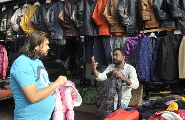 Mohammad Shariq, a deaf and mute cloth trader, interacts with a customer.(HT Photo)