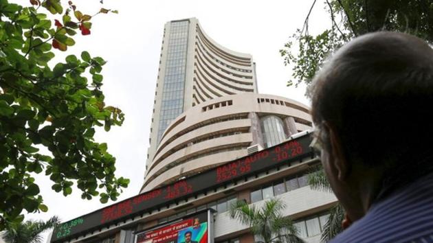 A man looks at a screen across a road displaying the Sensex on the facade of the Bombay Stock Exchange (BSE) building in Mumbai, India.(REUTERS)