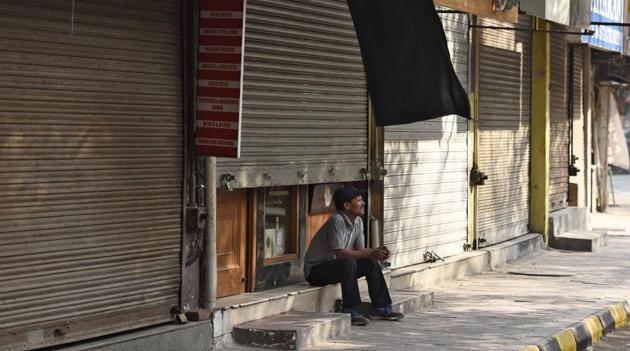 File photo of a person sitting outside a shop in the main market of Defence Colony, New Delhi.(Burhaan Kinu/HT PHOTO)