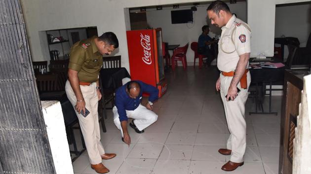 Police officials inspect the spot at Hotel Kolhapuri, where the businessman was shot at. The hotel is located on the service road of the Pune-Mumbai highway in Tathawade.(HT PHOTO)