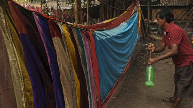 A worker sprays saris before they’re sent for polishing. Santu Choudhuri, secretary of South Dhobikhana Rajak Sangh spoke of diminishing resources, saying that the water supply has dropped to just twice a day, from the earlier four. The facility runs through approximately ten thousand litres of water daily, supplied from the Talla overhead tank, but that’s also decreasing gradually. (Samir Jana / HT Photo) A worker sprays saris before they’re sent for polishing. Santu Choudhuri, secretary of South Dhobikhana Rajak Sangh spoke of diminishing resources, saying that the water supply has dropped to just twice a day, from the earlier four. The facility runs through approximately ten thousand litres of water daily, supplied from the Talla overhead tank, but that’s also decreasing gradually. (Samir Jana / HT Photo)