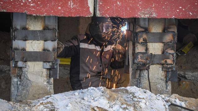 “There is a danger that it will tilt even more,” Romanov says while emergency welding is done in minus 35 degrees Celsius temperatures. Most Soviet-era apartment blocks here are made of concrete panels standing on stilts to ventilate the buildings’ underside and prevent heating the permafrost, a layer of soil cemented together with water that is only stable as long as it’s frozen. (Mladen Antonov / AFP) “There is a danger that it will tilt even more,” Romanov says while emergency welding is done in minus 35 degrees Celsius temperatures. Most Soviet-era apartment blocks here are made of concrete panels standing on stilts to ventilate the buildings’ underside and prevent heating the permafrost, a layer of soil cemented together with water that is only stable as long as it’s frozen. (Mladen Antonov / AFP)