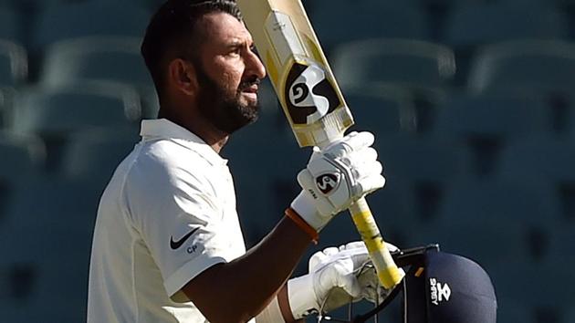 Cheteshwar Pujara celebrates scoring his century during day one of the first Test match against Australia.(AFP)